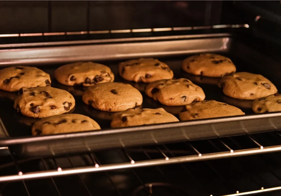 Chocolate chip cookies baking in oven.